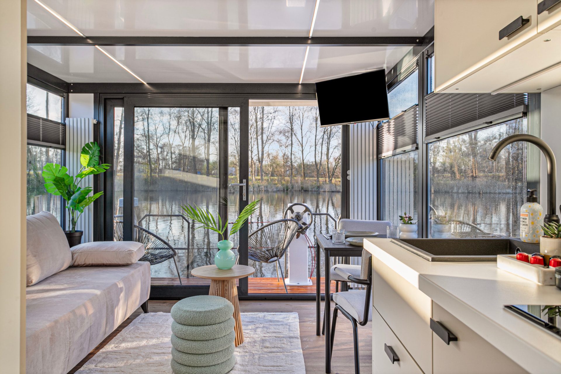 Licht interieur van een woonboot met uitzicht op het water